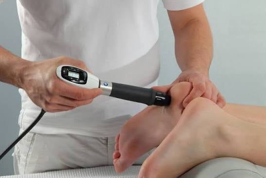 Healthcare provider using a handheld device to scan or measure a patients arm during a medical examination